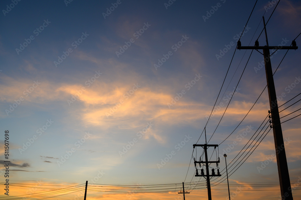 silhouette of electric poles and electric wires in the evening sunset high voltage poles in the beautiful orange and blue sky