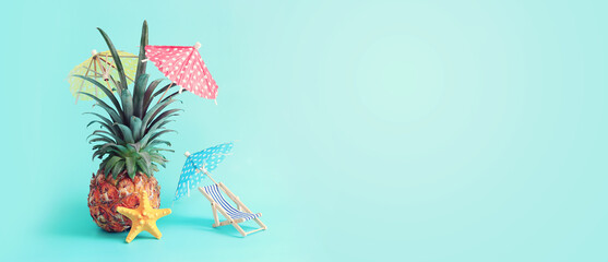Image with ripe pineapple with parasol and beach chair over blue background. Summer holidays and tropical theme