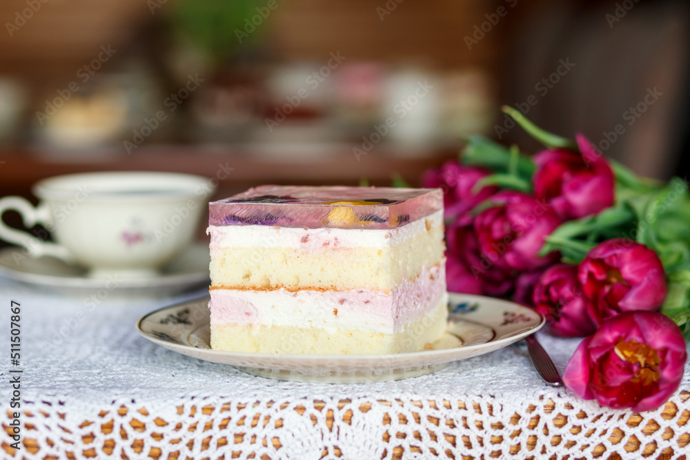 A piece of cake and a cup with a drink on the table. A piece of cake and a cup with a drink on the table.