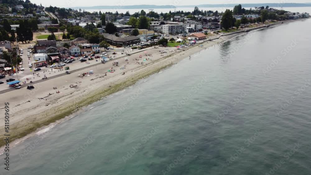 Counterclockwise drone shot of the shore and people enjoying a day at Alki Beach in Seattle. This 4K cinematic vacation shot was filmed using a DJI Mini 2 drone. Counterclockwise drone shot of the shore and people enjoying a day at Alki Beach in Seattle. This 4K cinematic vacation shot was filmed using a DJI Mini 2 drone.