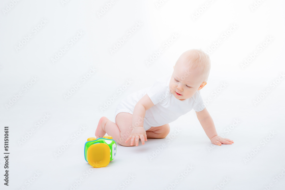 a baby boy in a white bodysuit is sitting playing with a car toy smiling on a white background a baby boy in a white bodysuit is sitting playing with a car toy smiling on a white background