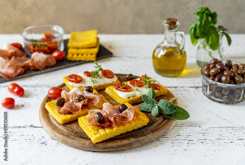 Cuadro en lienzo Grilled polenta with stracchino cheese, tomatoes, herbs, speck and olive