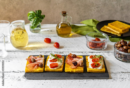 Photos Grilled polenta with stracchino cheese, tomatoes, herbs, speck and olive