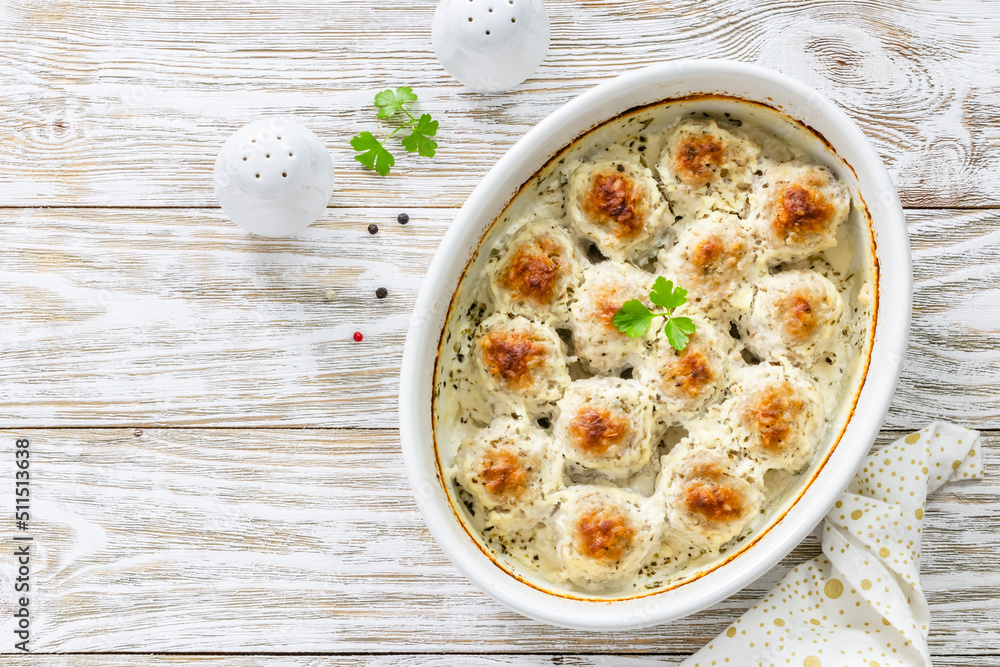 Sour cream meatballs in baking dish on wooden background. Top view, copy space, flat lay. Sour cream meatballs in baking dish on wooden background. Top view, copy space, flat lay.