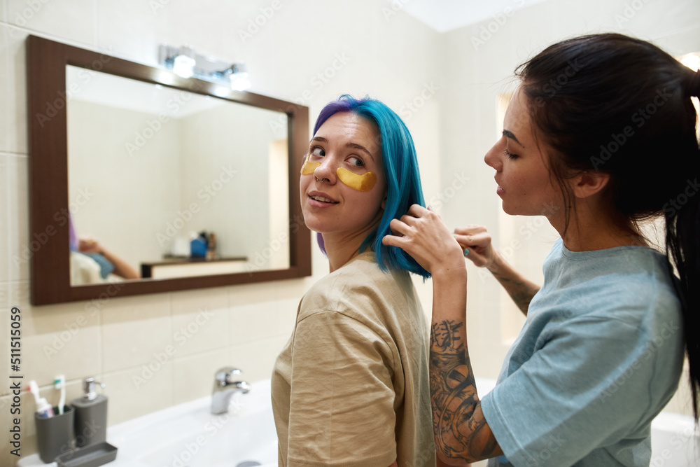 Fototapeta premium Girl combing colorful hair with comb of girlfriend