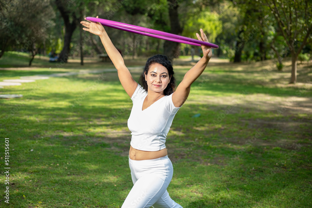 Beautiful Indian young woman doing workout with hula hoop in the park outdoor, Happy asian female do acrobat, sports and Fitness concept. Beautiful Indian young woman doing workout with hula hoop in the park outdoor, Happy asian female do acrobat, sports and Fitness concept.