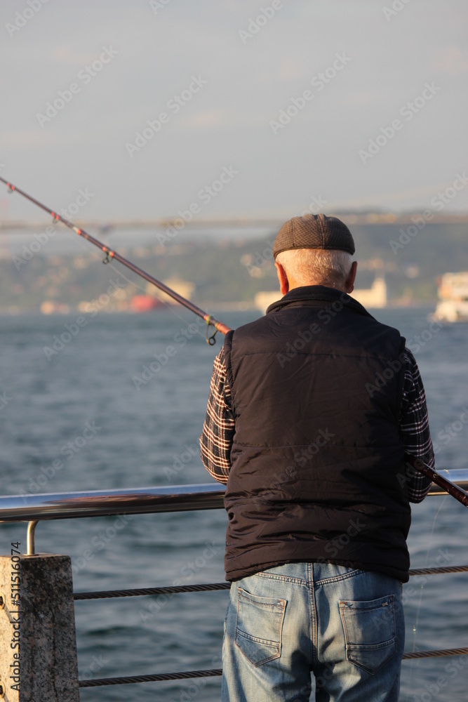 Obraz premium old man fishing in istanbul bosphorus