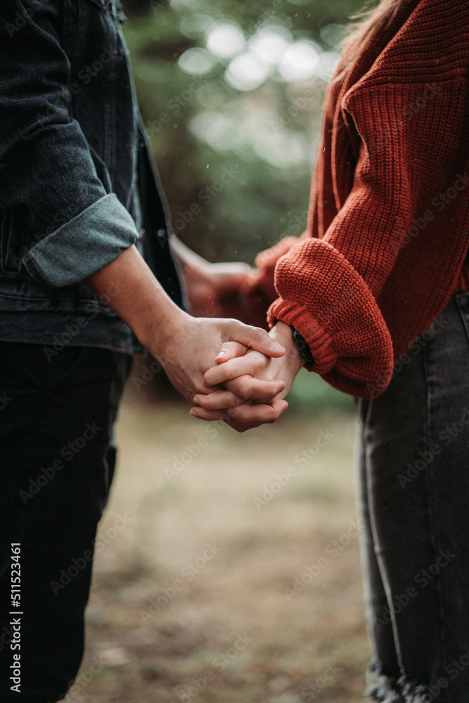 Couple holding hands in the woods