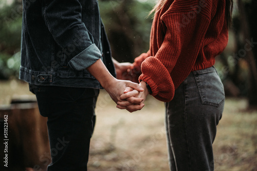 Couple holding hands in the woods photo