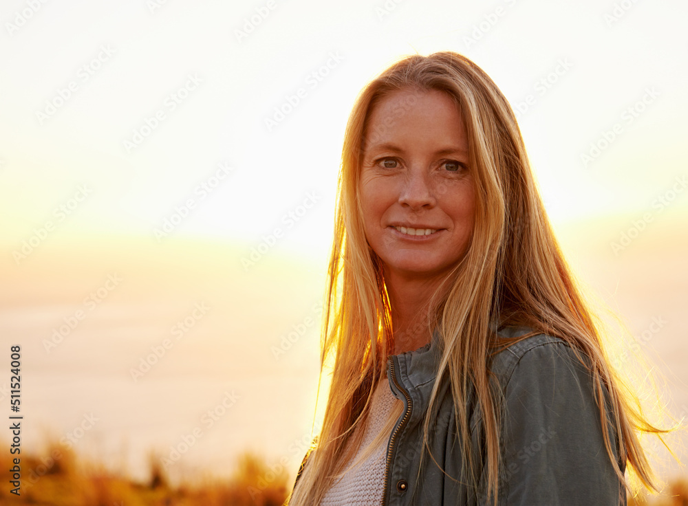 My favourite place to watch the sun set. Portrait of a beautiful young woman standing outside at sunset. My favourite place to watch the sun set. Portrait of a beautiful young woman standing outside at sunset.