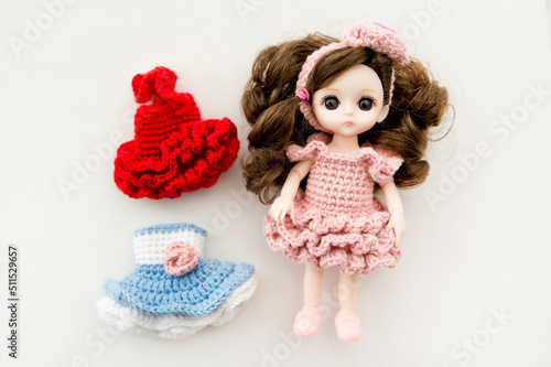 Print op canvas Baby girl cute doll with colorful hand crocheted knitting dress.