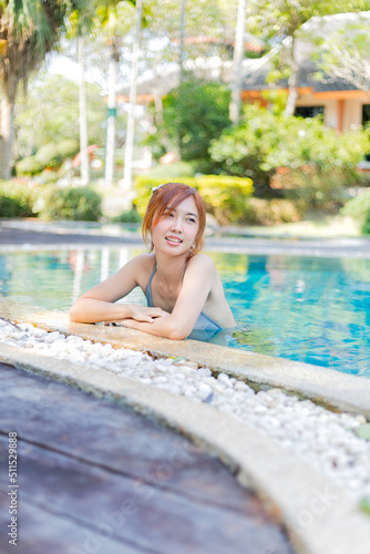 Beautiful Asian woman is in the pool and looks happy.