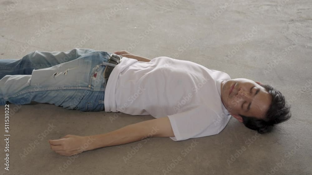 Man lying unconscious on cement floor due to extreme heat, heat stroke, global warming, CO2 emissions. Man lying unconscious on cement floor due to extreme heat, heat stroke, global warming, CO2 emissions.