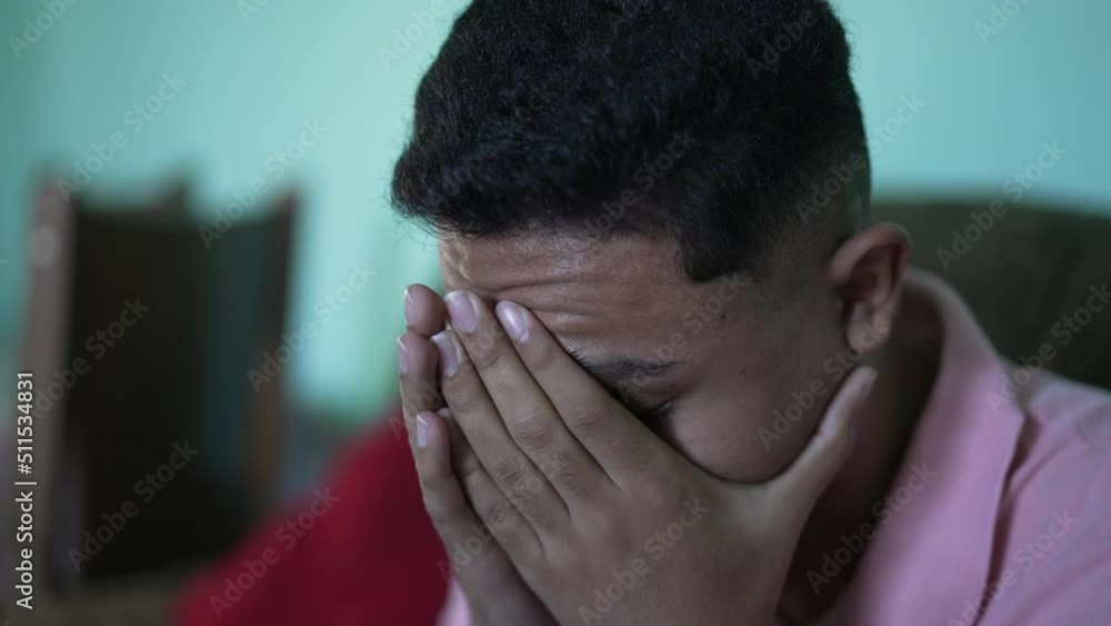 One anxious hispanic young man covering face with regret emotion One anxious hispanic young man covering face with regret emotion