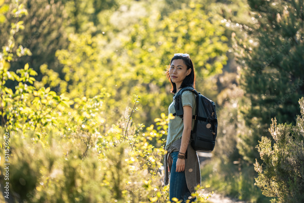 Traveling Asian woman with backpack walking in nature Traveling Asian woman with backpack walking in nature