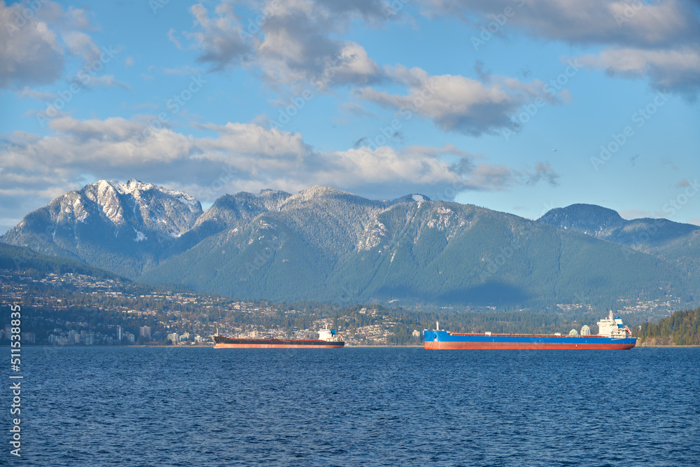 Freighters Anchored English Bay Vancouver. Anchored freighters in front of the Coast Mountains in English Bay.

