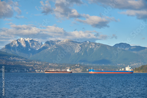 Freighters Anchored English Bay Vancouver. Anchored freighters in front of the Coast Mountains in English Bay.   © maxdigi