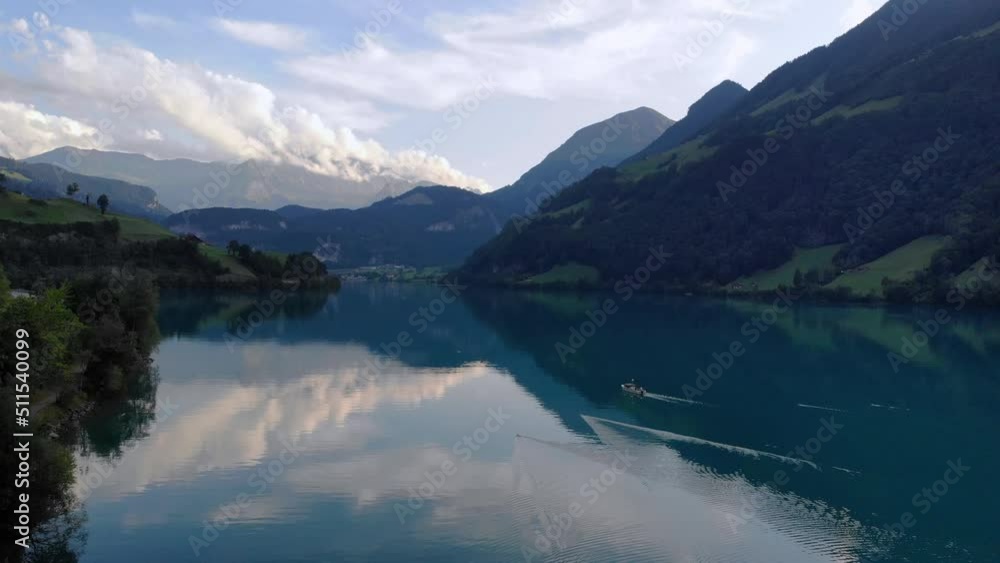 Scenic aerial view of fishing boat pulling net on Lungernersee lake, Switzerland Scenic aerial view of fishing boat pulling net on Lungernersee lake, Switzerland