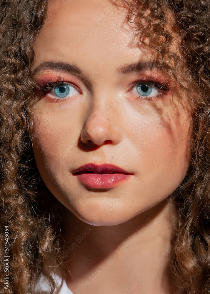 Beauty Portrait of a young girl with curly hair close-up. The girl with blue eyes Beauty Portrait of a young girl with curly hair close-up. The girl with blue eyes