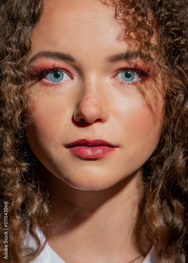 Beauty Portrait of a young girl with curly hair close-up. The girl with blue eyes Beauty Portrait of a young girl with curly hair close-up. The girl with blue eyes