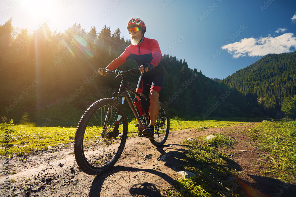 Mountain biker rides at the green forest in Kazakhstan