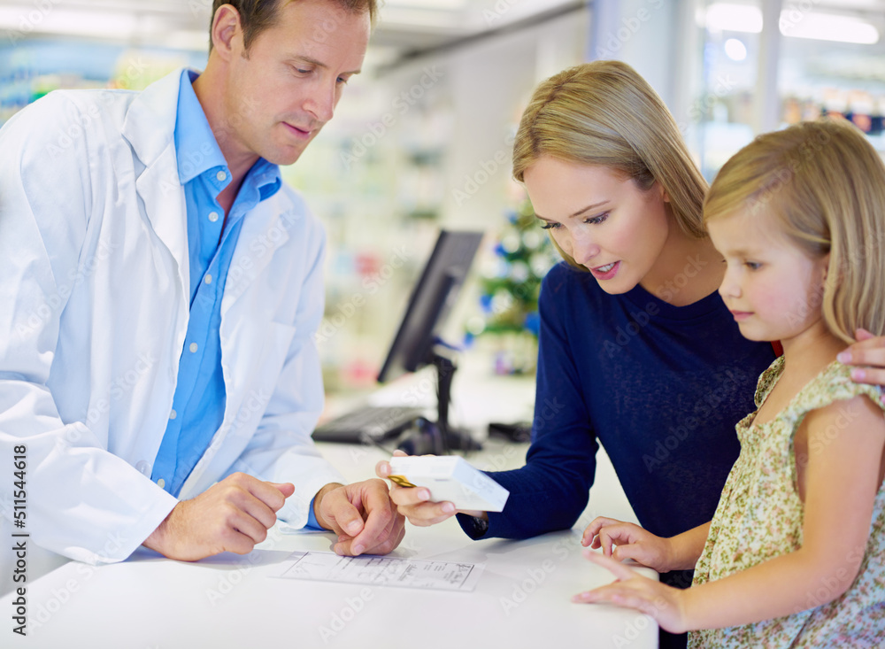 Fototapeta premium This is just what she needs. A pharmacist giving medication to a mother and daughter.
