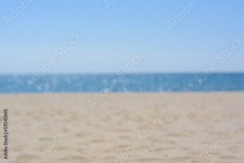 Sandy beach near sea on sunny day, blurred view