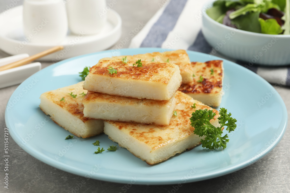 Delicious turnip cake with parsley served on grey table Delicious turnip cake with parsley served on grey table