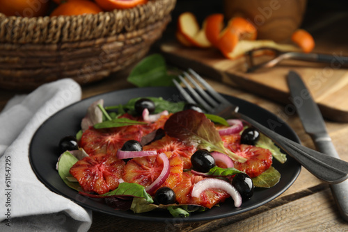 Plate of delicious sicilian orange salad on wooden table, closeup