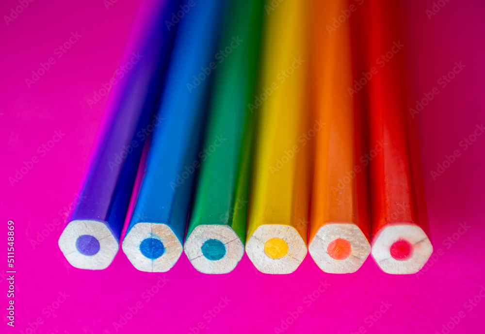 Six colored pencils seen from the top on pink cardboard that represent the colors of the rainbow and the flag of lgtbi rights Six colored pencils seen from the top on pink cardboard that represent the colors of the rainbow and the flag of lgtbi rights