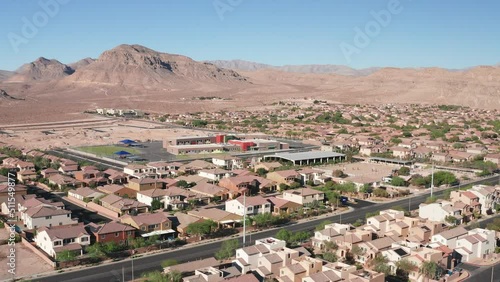 Aerial view of Las Vegas suburban homes, schools, horse ranch with mountains 