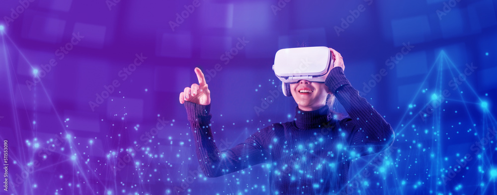 Asian woman wearing VR headset for entertainment in the metaverse. Augmented reality. Future digital technology game and entertainment. Metaverse technology concept.  - obrazy, fototapety, plakaty 