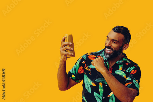 handsome african american man with portable speaker dancing listening music posing on yellow background studio shot photo