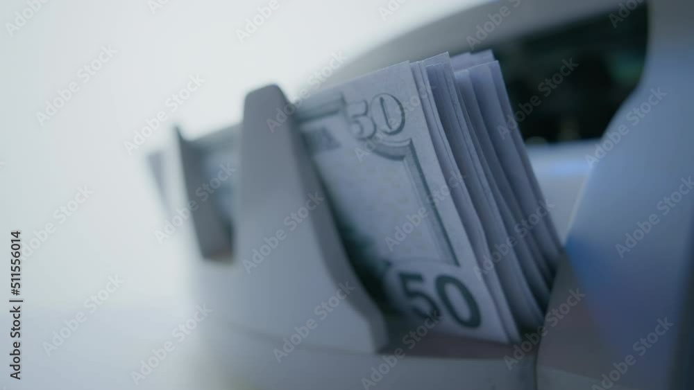 Money counting machine. Dollar banknotes on a bill counter. Modern bank equipment is processing usa currency. Automatic operations of cash. Banking or commercial activity and investment concept Money counting machine. Dollar banknotes on a bill counter. Modern bank equipment is processing usa currency. Automatic operations of cash. Banking or commercial activity and investment concept
