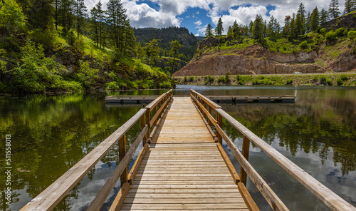 Wooden pier at summer sunny morning. Perspective view of wooden pier at summer lake in Canada