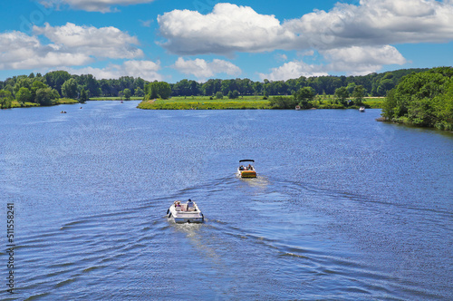 Beautiful idyllic dutch lakescape, 2 motor sport boats, green forest, ,blue summer sky - Leukermeer, Netherlands