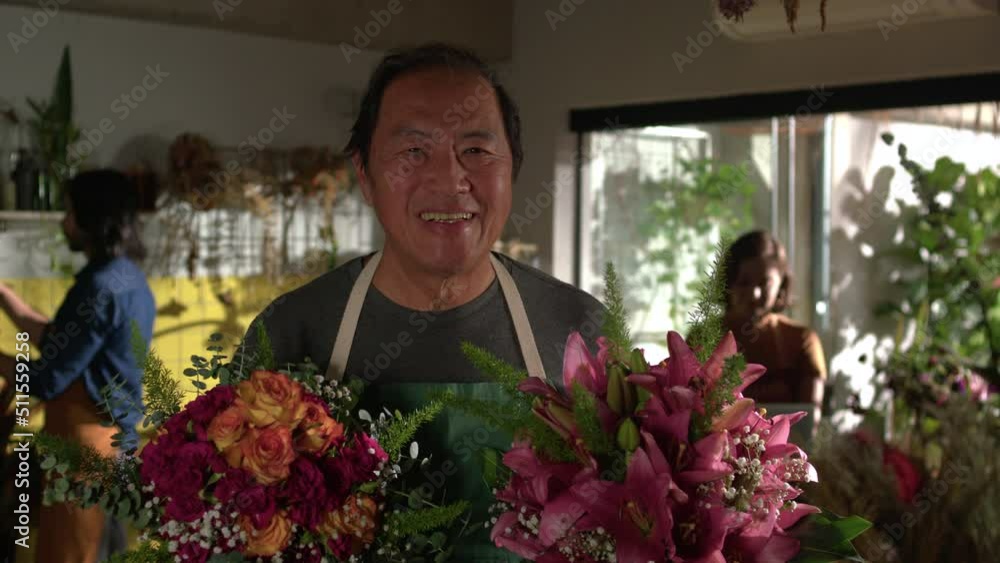 Portrait of an Asian florist holding two bouquet of flowers standing inside flower shop. Small business store entrepreneurship Portrait of an Asian florist holding two bouquet of flowers standing inside flower shop. Small business store entrepreneurship