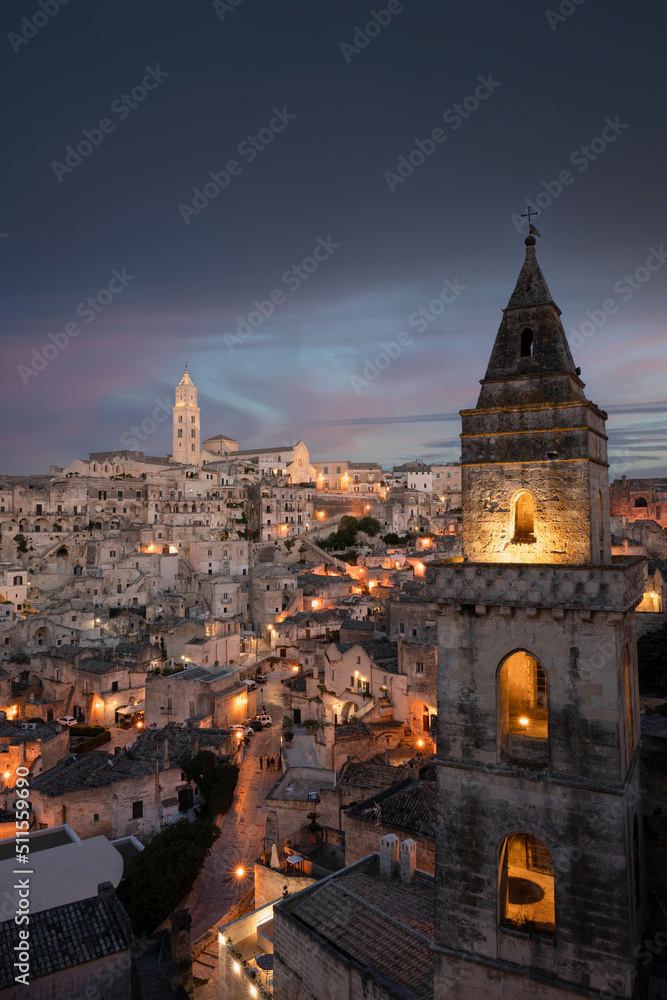 Stunning view of the illuminated village of Matera during a beautiful sunset. Matera is a city on a rocky outcrop in the region of Basilicata, in southern Italy.