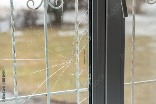 Glass broken by hooligans in a metal-plastic window, close-up