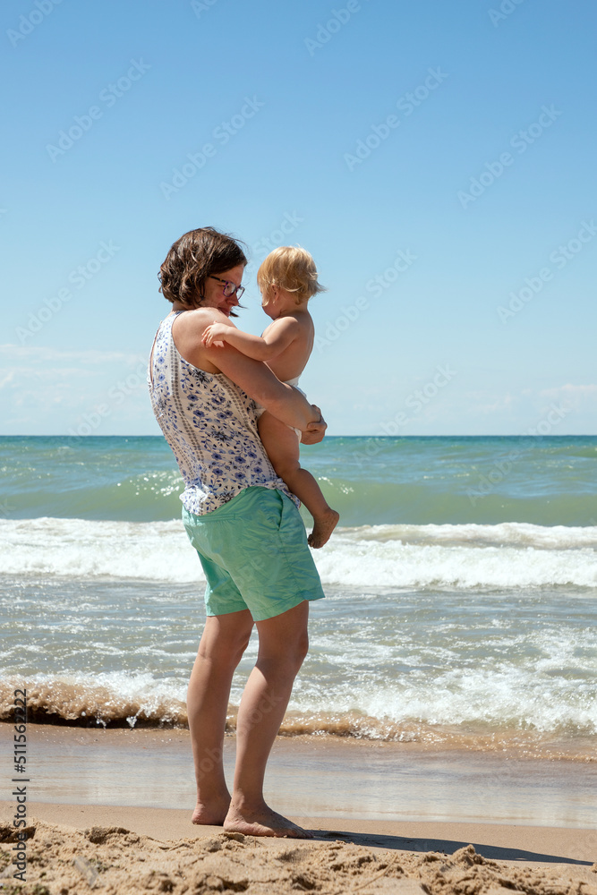 Mother and 1 year old daughter interacting at the Indiana Dunes National Park watching the waves of Lake Michigan roll in