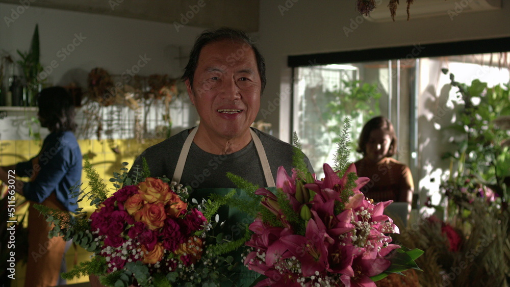 Portrait of an Asian florist holding two bouquet of flowers standing inside flower shop. Small business store entrepreneurship Portrait of an Asian florist holding two bouquet of flowers standing inside flower shop. Small business store entrepreneurship