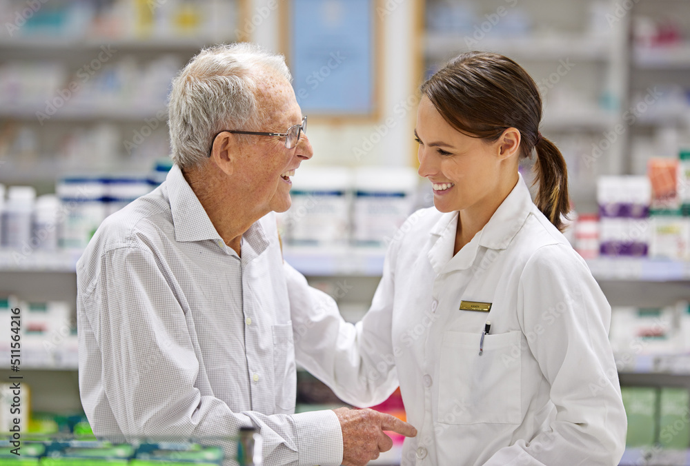 Obraz premium Every client is special to me. Shot of a young pharmacist helping an elderly customer.