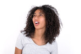 Young beautiful girl with afro hairstyle wearing gray t-shirt over white background yawns with opened mouth stands. Daily morning routine