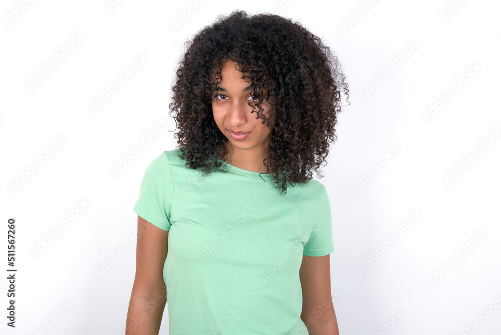 Offended dissatisfied Young beautiful girl with afro hairstyle wearing green t-shirt over white background with moody displeased expression at camera being disappointed by something Offended dissatisfied Young beautiful girl with afro hairstyle wearing green t-shirt over white background with moody displeased expression at camera being disappointed by something