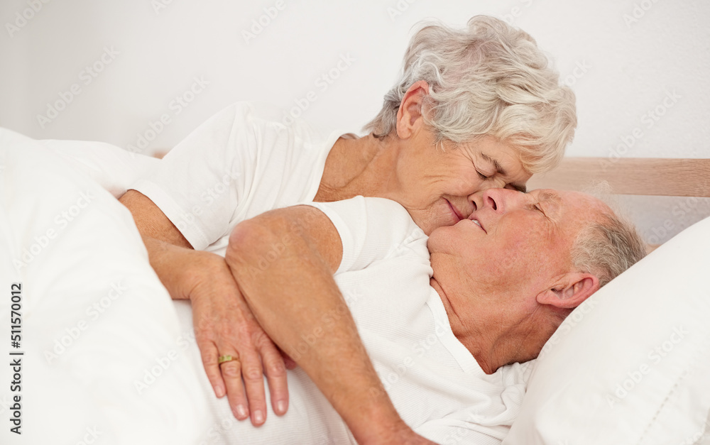 Rise and shine my love. Shot of a senior woman giving her husband a kiss in the morning. Rise and shine my love. Shot of a senior woman giving her husband a kiss in the morning.