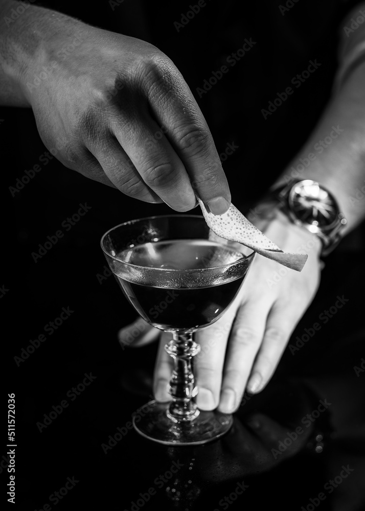 Delicious cocktail with alcohol served with garnish prepared by the bartender in the cocktail bar in dark colors