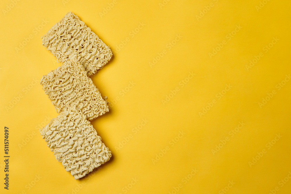 Obraz premium Instant noodles composition. Noodles and fresh vegetables and spices on yellow background