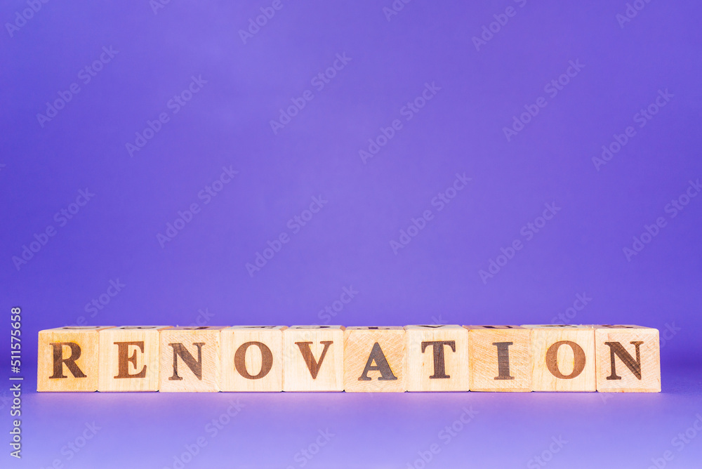 Renovation symbol. Wooden cubes with the word RENOVATION.Purple,veri peri color background. Business and renovation concept. Copy space. Renovation symbol. Wooden cubes with the word RENOVATION.Purple,veri peri color background. Business and renovation concept. Copy space.