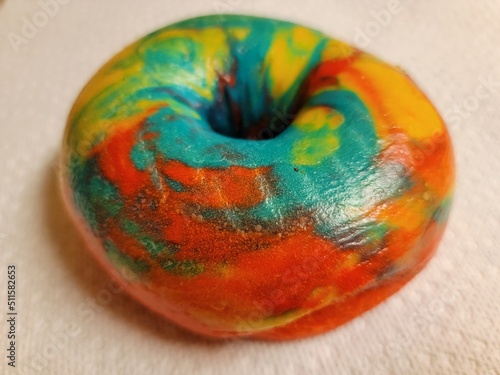 colorful bright rainbow bagel with many colors on counter