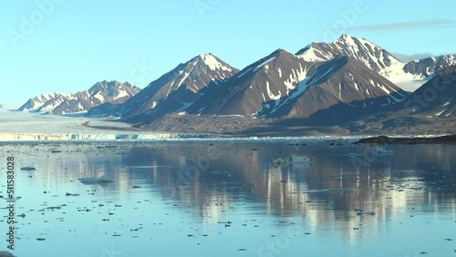 Moving Ice Floes on background of mountain on water of Arctic Ocean in Svalbard. Unique footage on background natural landscape and snow of Spitsbergen. photo